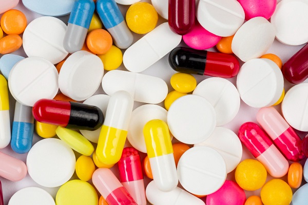 Diferentes medicamentos em comprimidos coloridos sobre uma superfície. 